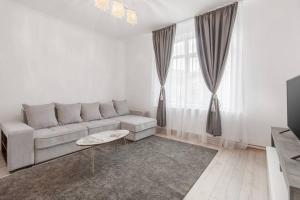 a white living room with a couch and a table at Azure Wave - Ultra Central in Oradea