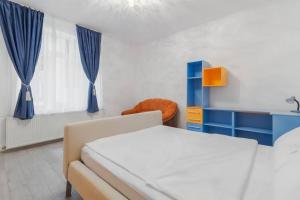 a bedroom with a bed and a blue cabinet and a window at Azure Wave - Ultra Central in Oradea