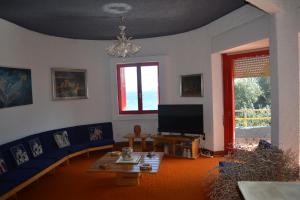 a living room with a blue couch and a tv at La casa di Aurora - Room A - Boutique Hotel in Agios Ioannis Peristerion