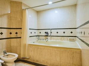 a bathroom with a tub and a toilet at Horison Ultima Menteng Jakarta in Jakarta +15 photos
