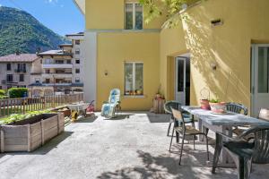 a patio with a table and chairs and a building at L'auberge le Toit Vert in Moutiers