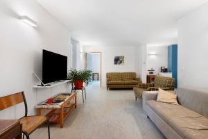 a living room with a couch and a tv at L'auberge le Toit Vert in Moutiers