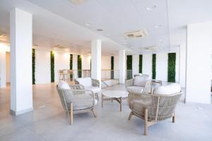 a waiting room with chairs and a table at BLUESEA Playa Azul in Cala en Porter +40 photos