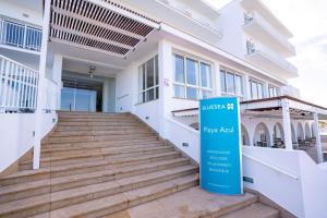 a building with a sign in front of it at BLUESEA Playa Azul in Cala en Porter