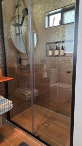 a shower with a glass door in a bathroom at Sunshine cottage in Clontarf