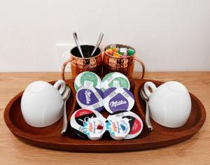 a plate of buttons on a wooden plate with two cups at Elohan Suite, parenthèse chic & cosy in Pontoise