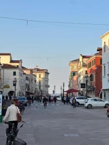 a group of people riding bikes on a city street at Casa Alba in Chioggia