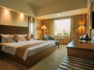 a hotel room with a bed and a desk at Horison Ultima Menteng Jakarta in Jakarta