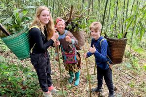 a woman and two children standing in the woods at The Happy Cozy Corner! in Lao Cai