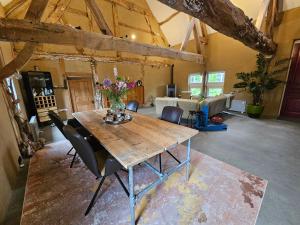 a dining room with a wooden table and chairs at B&B Bij Tante Toos in Lemiers