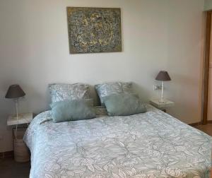 a bed with two pillows and a painting on the wall at Sur la route des vignerons - Clim - 1 Chambre in Courthézon