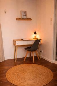 a desk with a chair and a table with a lamp at Sunshine cottage in Clontarf +3 photos
