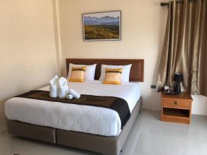 een slaapkamer met een groot bed met een nachtkastje en een bed sidx sidx sidx bij Lampang Green Garden Resort in Ban Chomphu