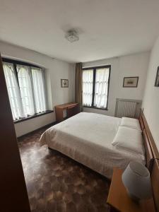a bedroom with a large bed and two windows at Villa Elisabetta in Malcesine