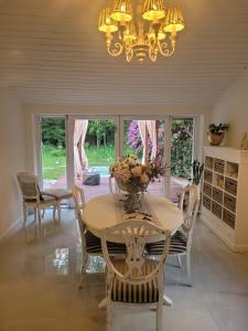 a dining room with a table with chairs and a chandelier at Natur Spa Haus in Niederkrüchten