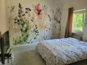 a bedroom with a bed with flowers on the wall at Natur Spa Haus in Niederkrüchten