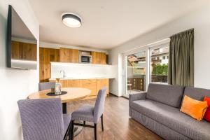 a living room with a couch and a table at Bergheim Plose - Appartements in St Andrä bei Brixen in Bressanone