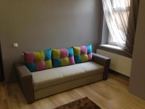 a couch with colorful pillows on it in a room at Apartment on Nezalezhnosti Embankment in Uzhhorod