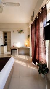 a living room with a couch and a kitchen at Hidden house stay in Mathura