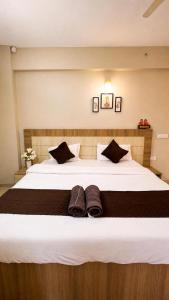 a large bed with two pairs of shoes on it at Hidden house stay in Mathura