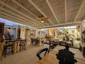 a patio with tables and chairs and a ceiling fan at Filizce Alaçatı in İzmir +28 photos