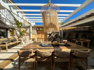 a patio with a table and chairs and a chandelier at Filizce Alaçatı in İzmir