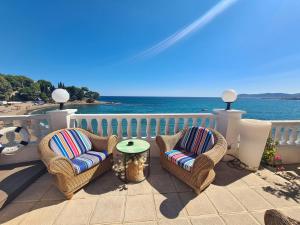 eine Terrasse mit Stühlen und einem Tisch und das Meer in der Unterkunft Hotel Grifeu y Restaurant - Costa Brava in Llança