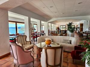 ein Wohnzimmer mit Sofa, Stühlen und einem Tisch in der Unterkunft Hotel Grifeu y Restaurant - Costa Brava in Llança