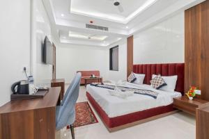 a bedroom with a large bed and a desk at Hotel The Balram in Ayodhya