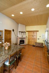 a large kitchen with a counter and a fireplace at Casa Del Palacio in Aguilafuente +3 photos
