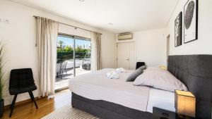 a bedroom with a large bed and a balcony at Villa Santa Rosa - Conforto e lazer com piscina e zona de jogos em Armação de Pêra in Armação de Pêra +64 photos