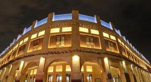 a building with lights on top of it at night at Gulf Pearls Hotel in Doha