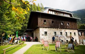 a group of people sitting in chairs in front of a building at Rooms Jagoda I Cozy Alpine Stay Near Bled in Blejska Dobrava