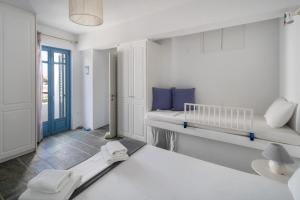 a white room with two beds and a window at Almira 2 in Livadakia