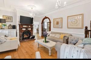 a living room with two couches and a fireplace at Middleton House Maleny in Witta
