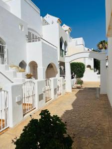 a white building with a gate in a courtyard at Apartamento de las Buganvillas in Vera