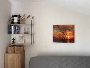 a bedroom with a bed and a picture on the wall at Vasara Noānā in Plieņciems