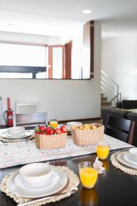 a table with plates and bowls of fruit on it at Casa de Freixo Casa de Freixo Refugio Tranquilo na Natureza in Ponte de Lima