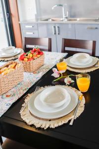 a table with plates and bowls of fruit on it at Casa de Freixo Casa de Freixo Refugio Tranquilo na Natureza in Ponte de Lima