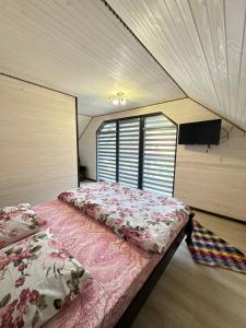 a bedroom with two beds and a large window at Котедж у Софійки in Synevyrsʼka Polyana