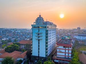a tall white building with the sunset in the background at Horison Ultima Menteng Jakarta in Jakarta