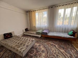 a bedroom with two beds and a large window at Temirbek Guest House in Jangy-Talap