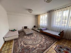 a living room with two couches and a rug at Temirbek Guest House in Jangy-Talap