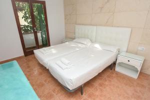 a white bed in a room with a window at Home D'or in Cala d´Or