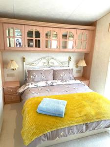 a bedroom with a bed with a yellow blanket at Sun rise in Macclesfield