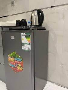 a refrigerator with a tea kettle on top of it at شقق وجهة الوصول in Ar Rawshān