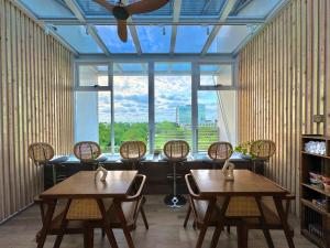 a room with two tables and chairs and a large window at 安平胡桃民宿-免費停車-專屬電梯-公園景觀 #包棟可使用娛樂設施 in Tainan