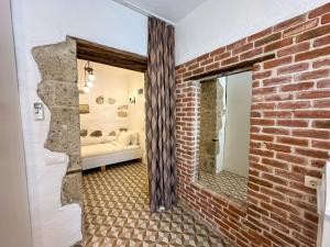 a room with a brick wall and a mirror at Filizce Alaçatı in İzmir