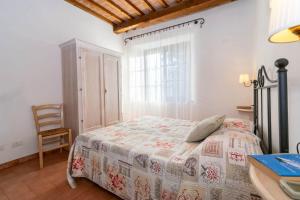 a bedroom with a bed and a chair and a window at Residence La Casaccia in Venturina Terme +119 photos