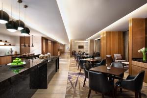a restaurant with tables and chairs and a bar at The Westin Jakarta in Jakarta